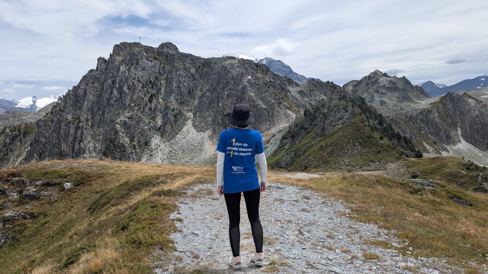 Jeune fille regardant la montagne et portant un tee-shirt 1 don de moelle = 1 vie sauvée